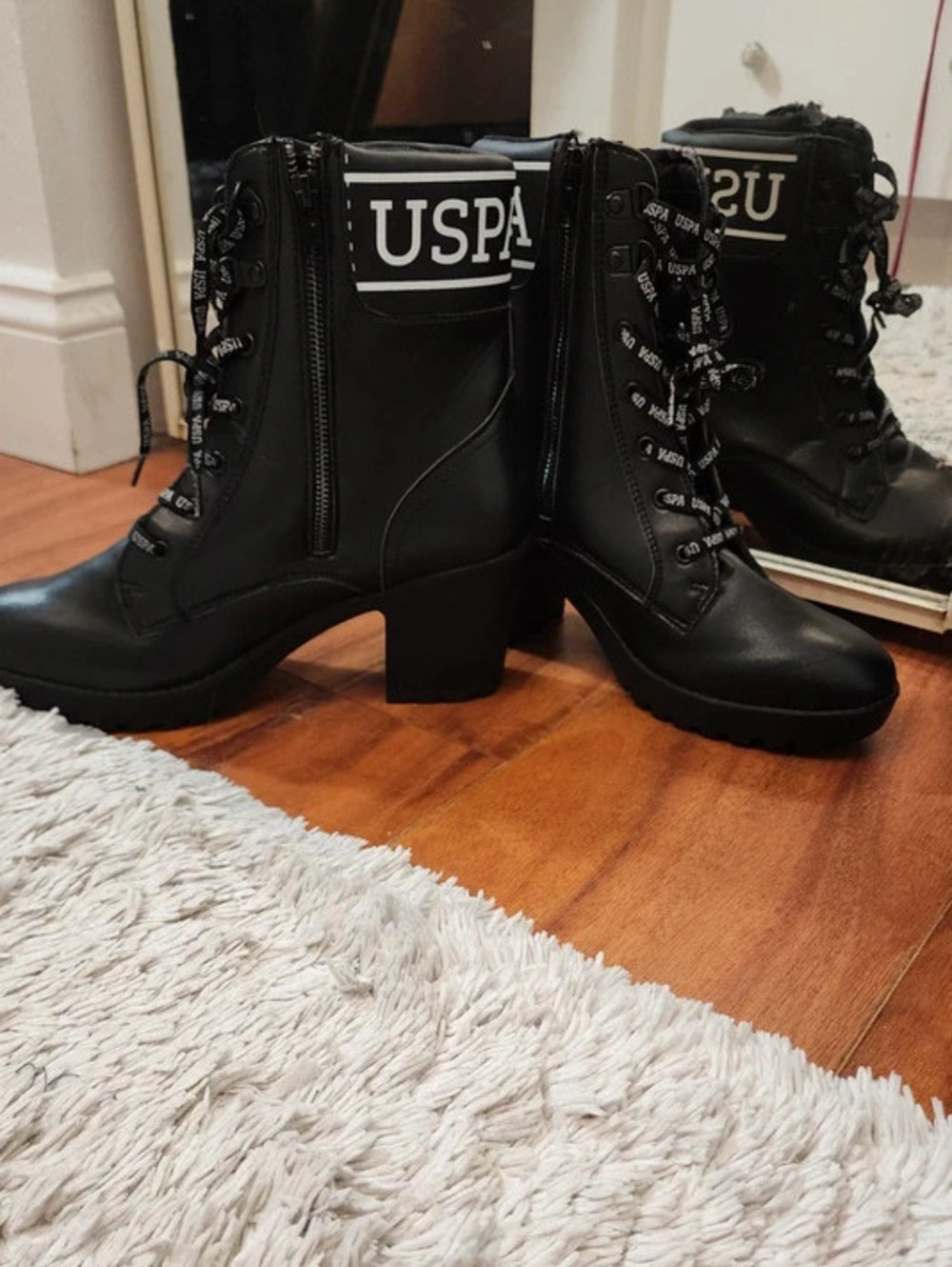 Black lace up heeled combat ankle boots with side zip and lug platform sole.